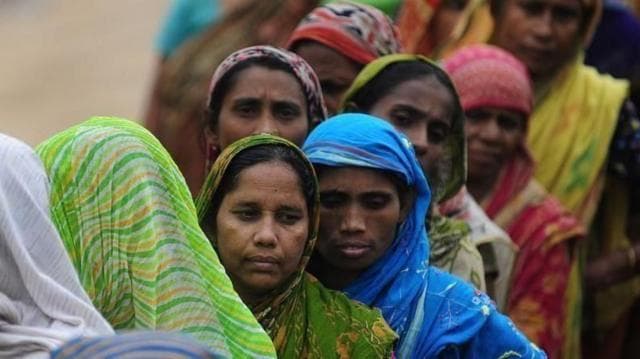 কয়েকজন নারী লাইনে দাঁড়িয়ে আছেন