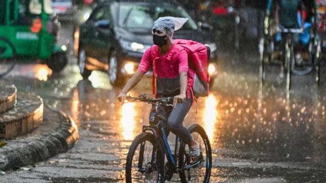 বৃষ্টিতে ভিজেই পণ্য ডেলিভারি দিতে যাচ্ছেন একজন ডেলিভারিম্যান