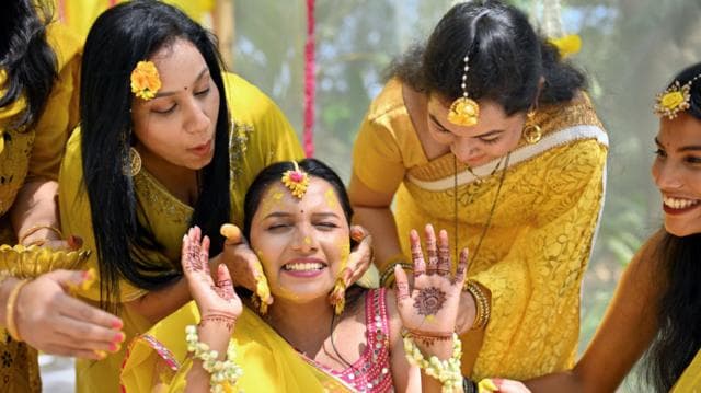ভারতীয় কনের পরিবারের নারী সদস্য ও বান্ধবীরা তাকে ঘিরে ‘হলুদ’ অনুষ্ঠানের সময় গায়ে হলুদের প্রলেপ লাগাচ্ছেন। নারীরা উজ্জ্বল হলুদ রঙের শাড়ি পরে আছেন; তাদের কপালে হলুদ রঙের অলংকার এবং হাতে মেহেদি লাগানো।