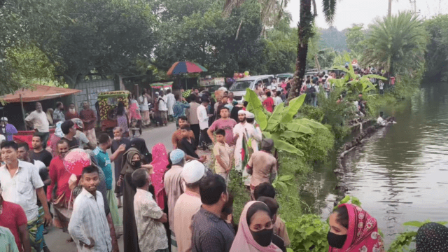 একটি পুকুরের পাশে মানুষের ভিড়